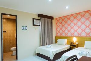 马尼拉利亚诺酒店的酒店客房设有两张床和卫生间。