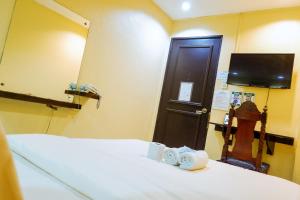 马尼拉利亚诺酒店的一间设有床、镜子和门的房间