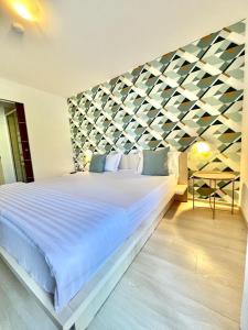北马马亚-讷沃达里Ido的卧室配有一张白色大床和几何墙
