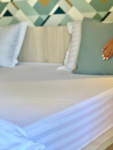 北马马亚-讷沃达里Ido的一张带白色床单和枕头的床