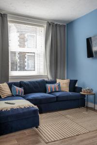 MorristonStay at the Marine House - TV in every bedroom!的蓝色的客厅设有蓝色的沙发和窗户