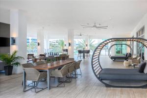 达尼亚滩AC Hotel by Marriott Fort Lauderdale Airport的客厅配有桌椅和沙发