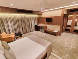 孟买HOTEL ARCHANA RESIDENCY的配有一张床和一张书桌的酒店客房