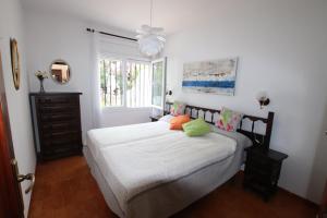 坎布里尔斯Planta baja, primera linea, playa, jardín privado, Ardiaca, Cambrils, apartamento Jacqueline的一间卧室配有一张带白色床单的床和一扇窗户。