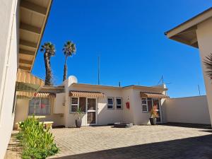 斯瓦科普蒙德Bushbabies-Inn Self-Catering Accommodation的一座白色的房子,后面有棕榈树