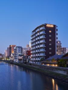 福冈ALFACIO RIVERSIDE STAY HAKATA的河岸边有标志的高楼