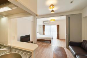 福冈ALFACIO RIVERSIDE STAY HAKATA的客厅配有沙发和1张床