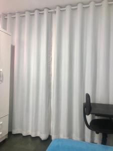 巴西利亚Pousada 714的椅子房间里白色窗帘