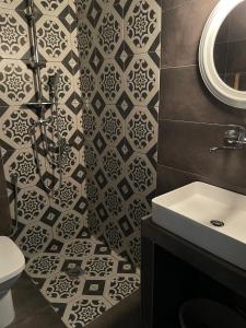 佩科霍里Xenios Hotel的浴室设有黑色和白色的瓷砖墙。