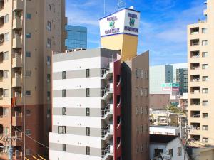 府中市HOTEL LiVEMAX BUDGET Fuchu Annex的一座高大的建筑,上面有一座塔