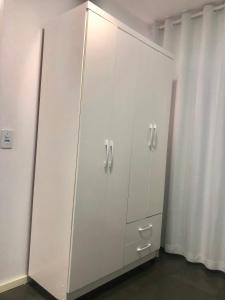 巴西利亚Pousada 714的客房内的白色衣柜和白色橱柜