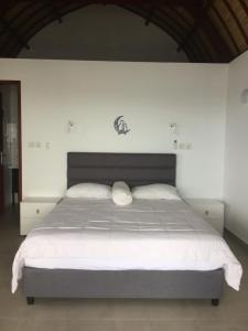 艾湄湾吉利佩索纳别墅的一间卧室配有一张带白色床单的大床