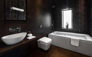 孟买Arnna Hotel- Goregaon East的带浴缸、卫生间和盥洗盆的浴室
