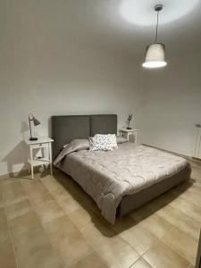 罗卡迪坎比奥Casa Rocca di Cambio的一间卧室配有一张带两张桌子和一盏灯的床