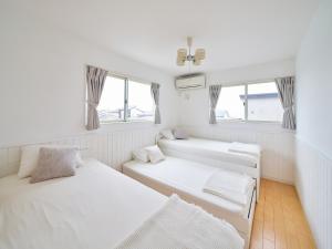 横须贺市Villa OLIVE Sajima -佐島の丘- ペット可的带2扇窗户的客房内的2张床