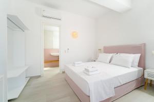波托什Filoxenia Luxury Apartments的白色粉红色的卧室设有一张床和一间浴室