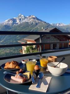 拉赫兹耶尔Hôtel Alpen Lodge的一张桌子,上面有食物,后面有山