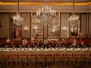 巴黎Hôtel Plaza Athénée - Dorchester Collection的一间带长桌和吊灯的用餐室