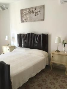 孔韦尔萨诺La dimora dei ricordi的一间卧室配有一张大床和两张桌子