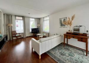 阿珀尔多伦Center Appartement Apeldoorn的客厅配有白色沙发和钢琴