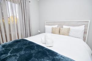 比勒陀利亚Cosy Hatfield Apartment的卧室配有白色的床和窗户。