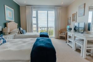 莫塞尔湾Pinnacle Point Lodge 21的一间卧室设有两张床、一张桌子和一个窗口。
