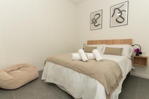 科尔多瓦Lofts Jumaral - La Magdalena的一间卧室配有一张大床和一张搁脚凳