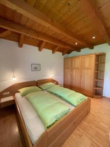 波斯特尔Feldererhof的一间卧室配有一张带绿色枕头的大床