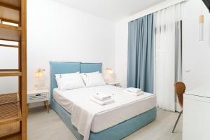 波托什Filoxenia Luxury Apartments的卧室配有蓝色和白色的床和窗户。