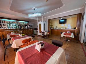 那不勒斯马提尼酒店的一间带2张桌子的餐厅和一间酒吧