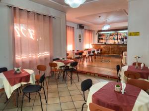 那不勒斯马提尼酒店的一间带桌椅的餐厅和一间酒吧