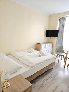 斯维诺乌伊希切Lazur Apartamenty的一间卧室配有两张床、一张桌子和一把椅子