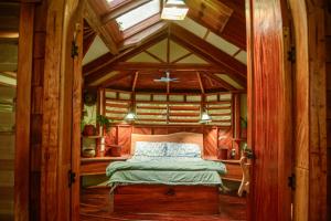 MakaungaTukulolo Treehouses的一间卧室设有一张木天花板床。