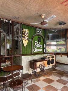 卡兰巴Hotspring Resort with Videoke的一间设有椅子、桌子和标志的餐厅