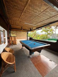 卡兰巴Hotspring Resort with Videoke的配有台球桌和两把椅子的房间