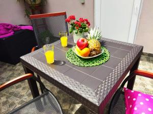 罗波里卡Kuća Lilla的一张桌子,上面放着一碗水果和两杯橙汁