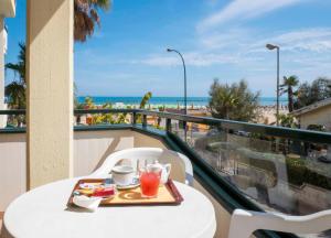 阿布鲁齐的罗塞托Hotel Roma Sul Mare的海滩阳台的桌子上放着一盘食物