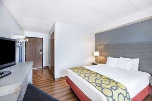 吉列Baymont by Wyndham Gillette的配有一张床和一台平面电视的酒店客房