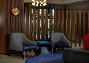堪萨斯城Hilton Kansas City Country Club Plaza的大堂设有两把椅子和一张沙发