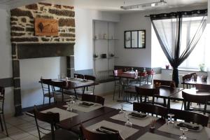 Talizat普拉尼耶旅馆的一间带桌椅和壁炉的用餐室