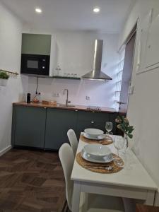 maison du olival的厨房配有白色的桌椅和水槽