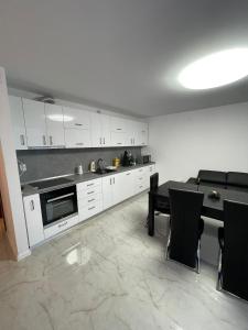 德瓦Regim Hotelier DEVA, str. Mihai Viteazu, bl. RESIDENCE !!!的厨房配有白色橱柜和桌椅