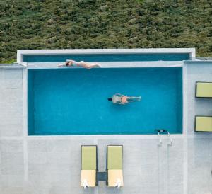 ExanthiaAnadeo Villas & Suites的一个人在游泳池游泳