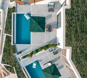 ExanthiaAnadeo Villas & Suites的享有带遮阳伞的游泳池的顶部景致
