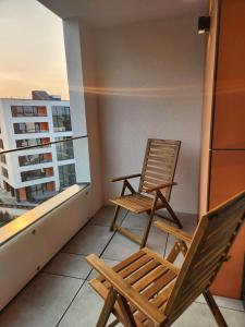 维尔纽斯Prie Vilneles Apartment的两把椅子坐在公寓的阳台上
