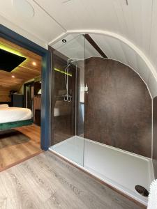 康福斯Wonderland Retreats的卧室内的玻璃淋浴间,配有床