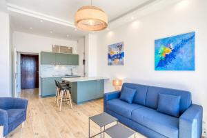 尼斯#43 Design Studio Terrace AC Wifi Sea View 1min Beach的一间带蓝色沙发的客厅和一间厨房