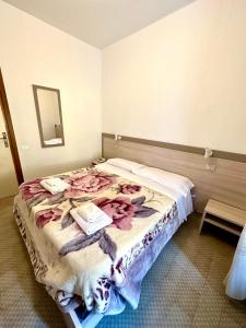 斯培西亚奥罗拉酒店的一间卧室配有一张带鲜花的大床