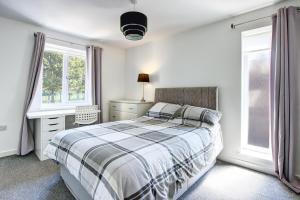 桑德兰Sunderland Short Stays 2 bedroom apartment Free Parking Fulwell SR6的卧室配有一张床、一张书桌和窗户。