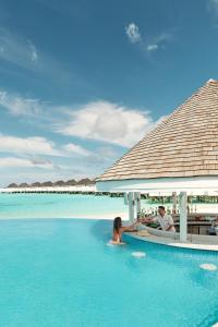 丹格迪Nova Maldives的坐在海洋游泳池中的男女